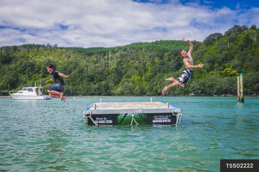 Kids Jumping off Platform into Ocean