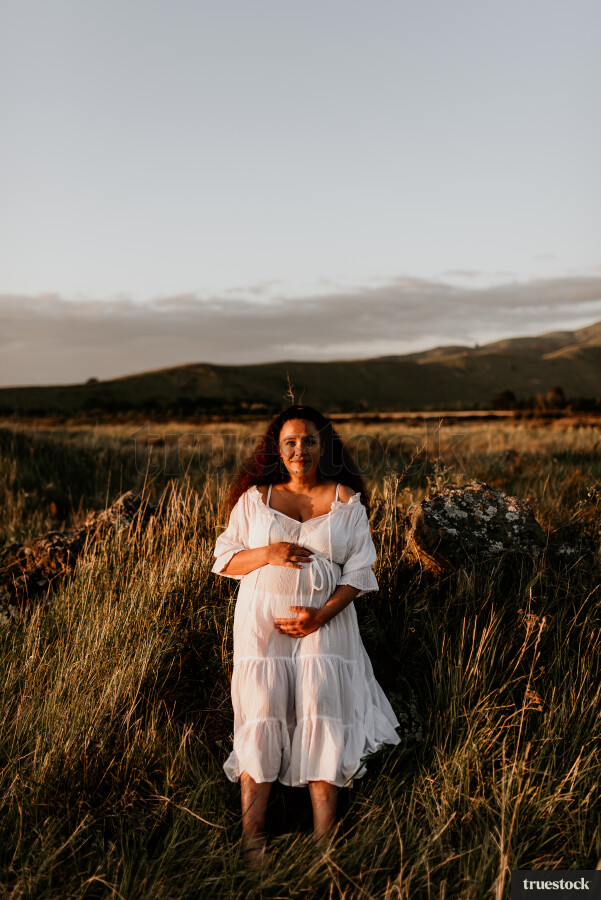 Woman Standing in Field for Maternity Shoot