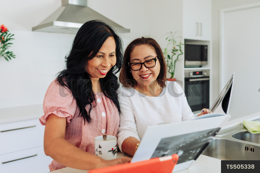 Women Using Device in Kitchen