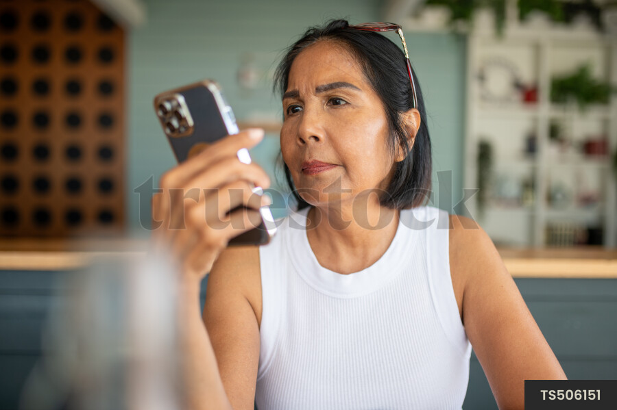 Asian woman using smart phone in house