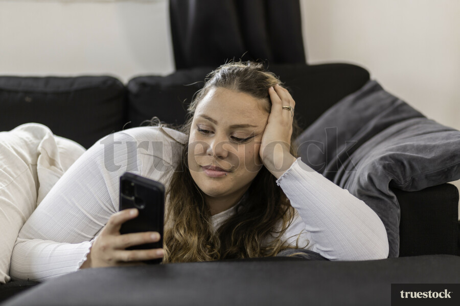 Mother Using Phone on Couch