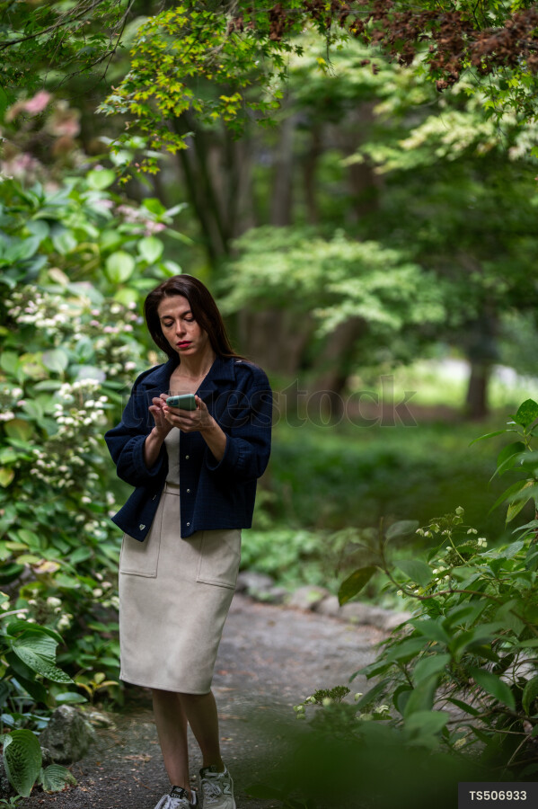 Young woman with smart phone in park