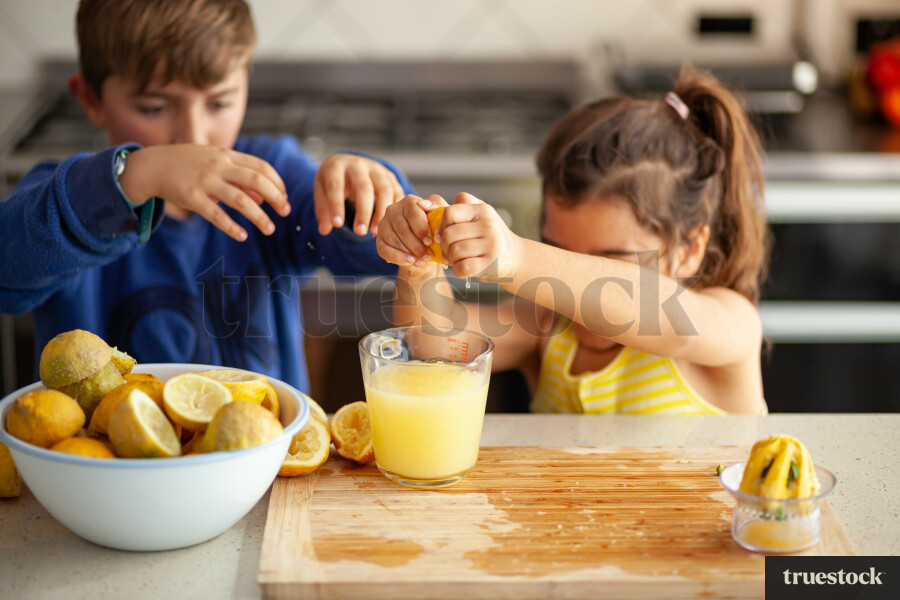 Young children making lemondade