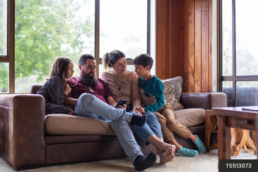 Family Using Phone on Couch