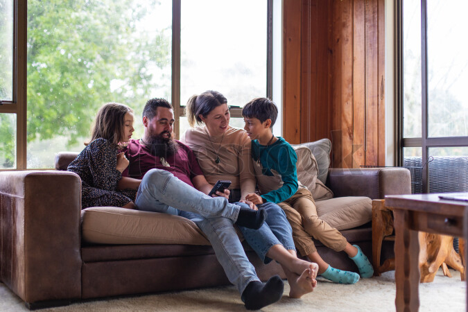 Family Using Phone on Couch