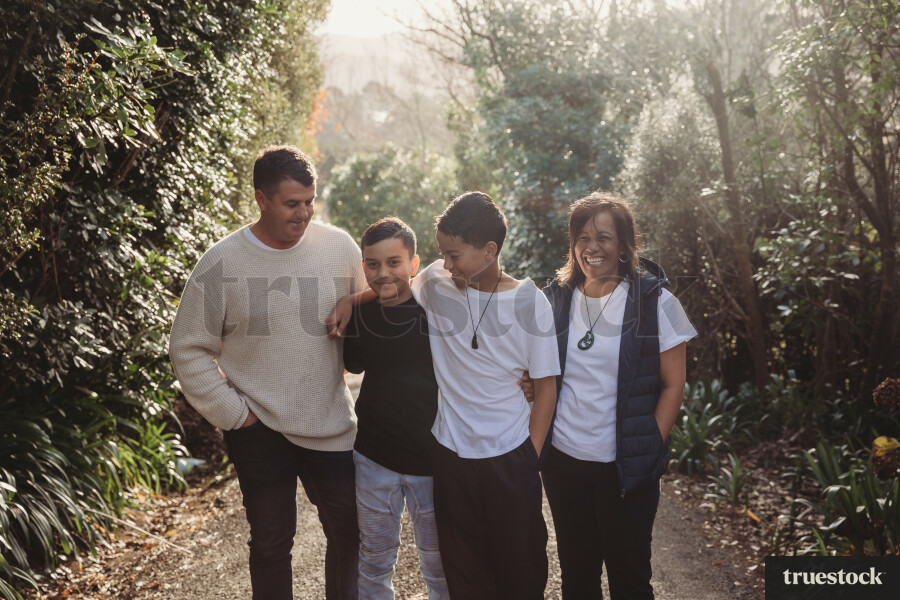 Portrait of happy smiling family with sunbeams through the trees