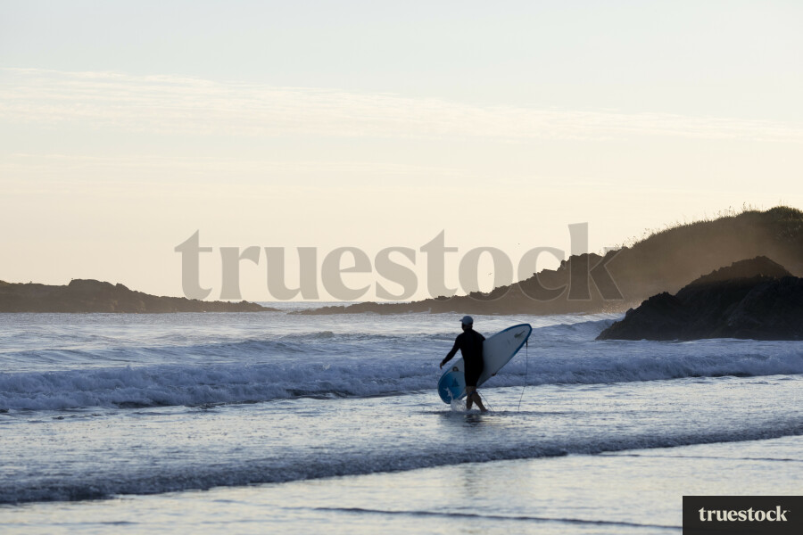 Surfer entering waves
