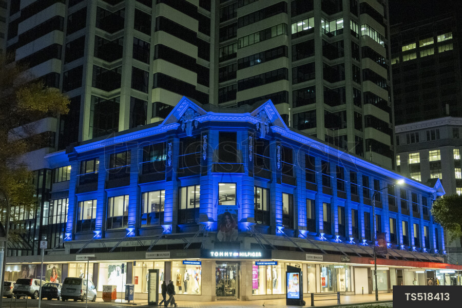 Pedestrians walking outside buildings at night