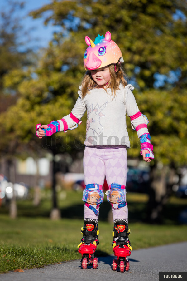 Girl roller skating on sidewalk in park
