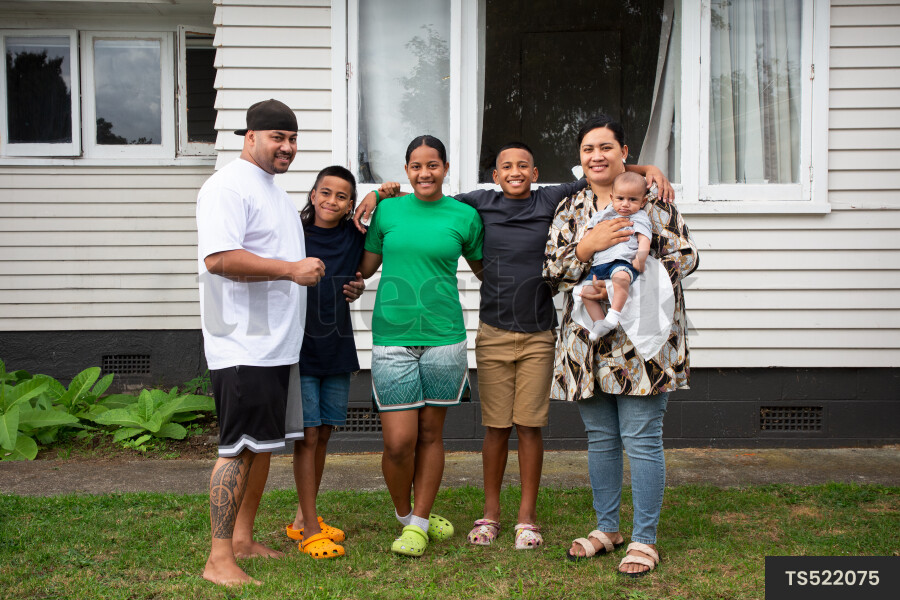 Portrait of happy tongan family outside house