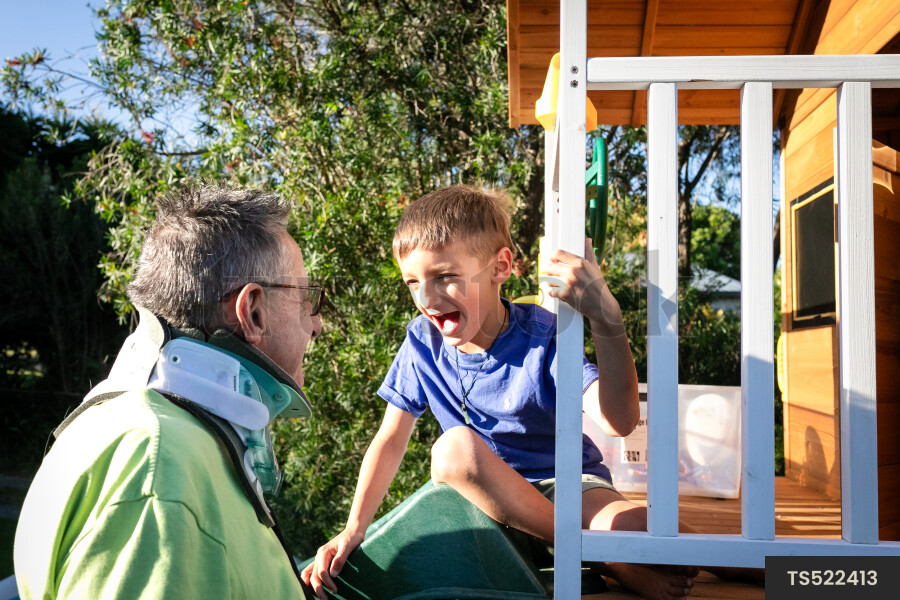Man playing with grandson in playhouse