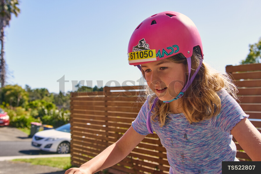 Girl wearing bicycle helmet in residential neighborhood