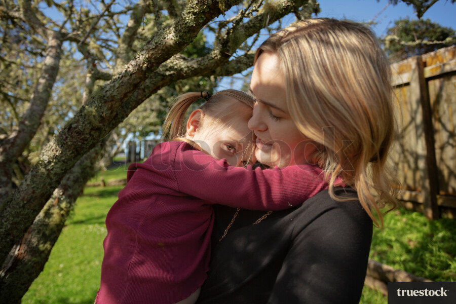 Daughter Hugging Mother in Bakcyard