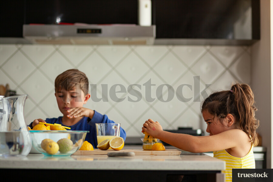Young children making lemondade