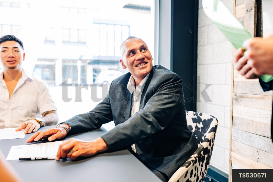 Businesspeople smiling during meeting in boardroom