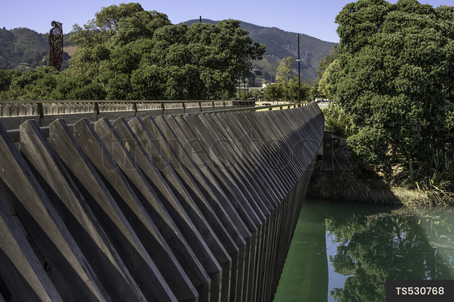 Bridge over river with trees by mountain