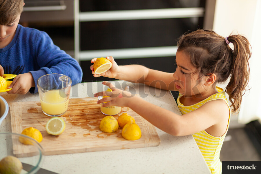 Young children making lemondade