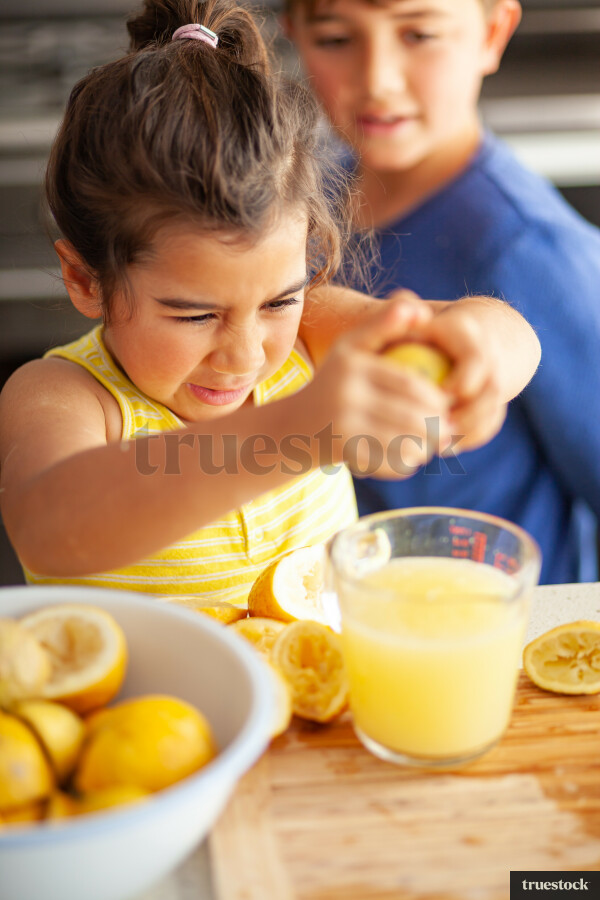 Young children making lemondade