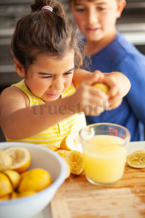 Young children making lemondade