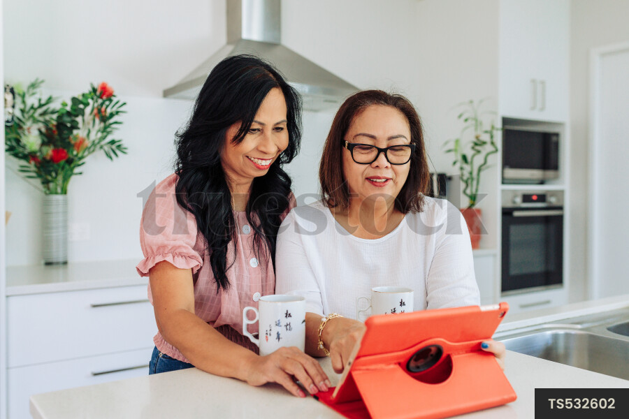 Women Using Device in Kitchen