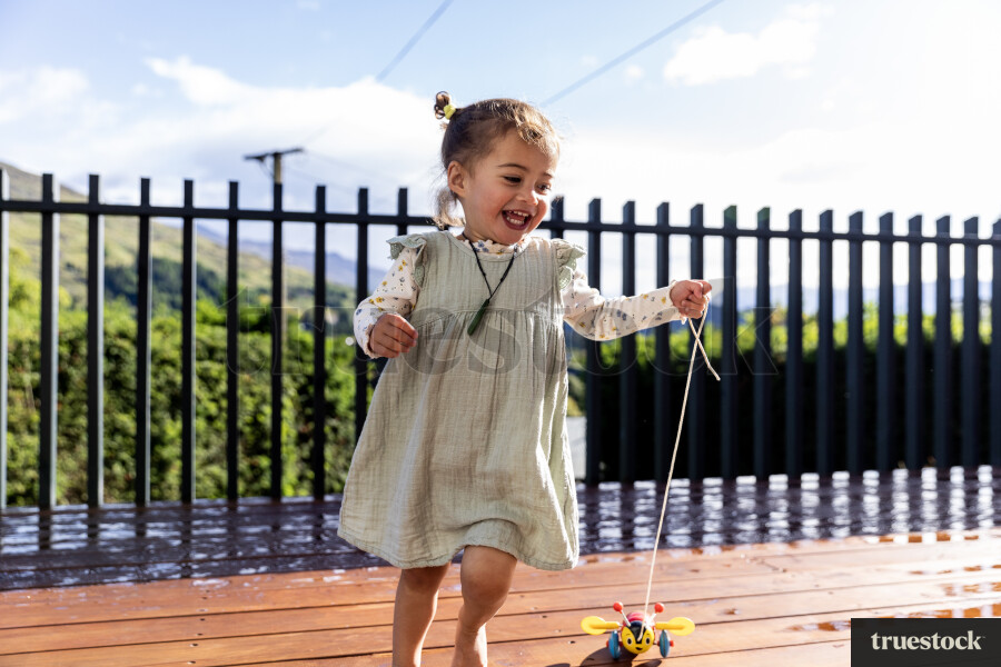 Young Girl Playing With Toy on Deck