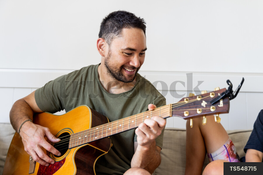 man Playing Guitar at Home