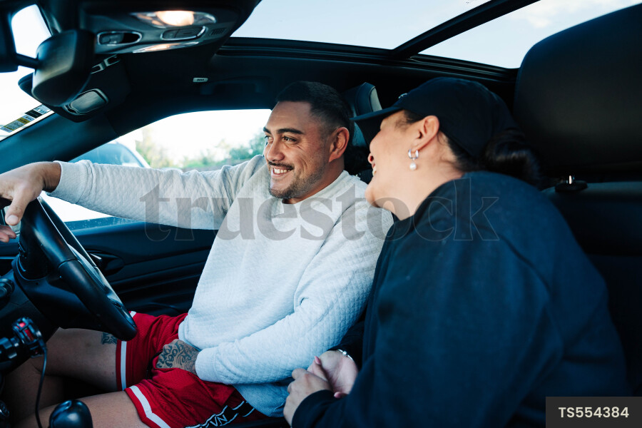 Husband and wife sitting and smiling in car