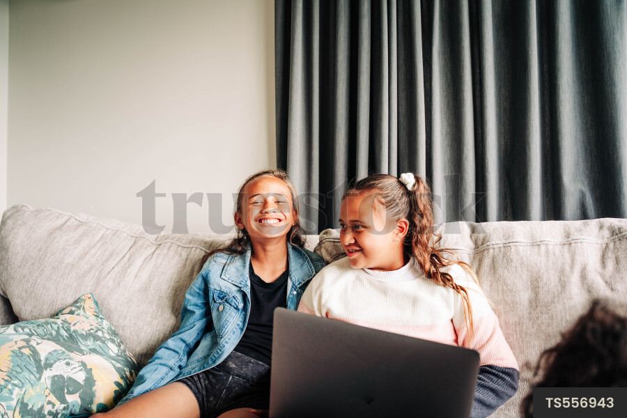 Girls with laptop sitting on sofa