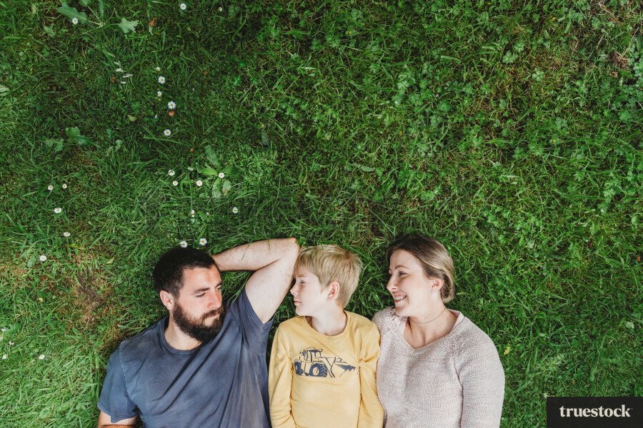 Parents and child lying on lawn