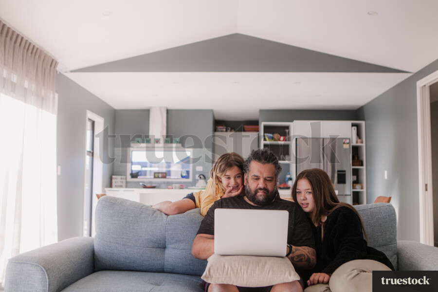 Whānau Using a Laptop on the Couch
