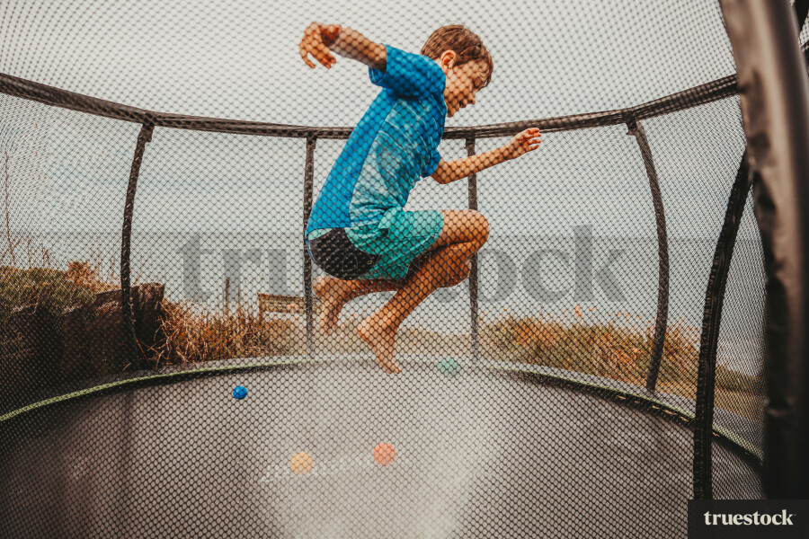 Child jumping on a trampoline at the beach