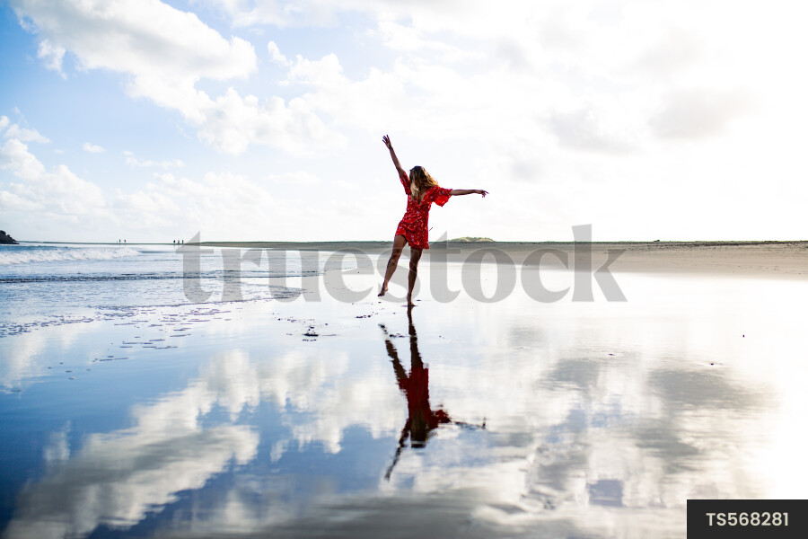 Woman on Whatipu Beach during sunset