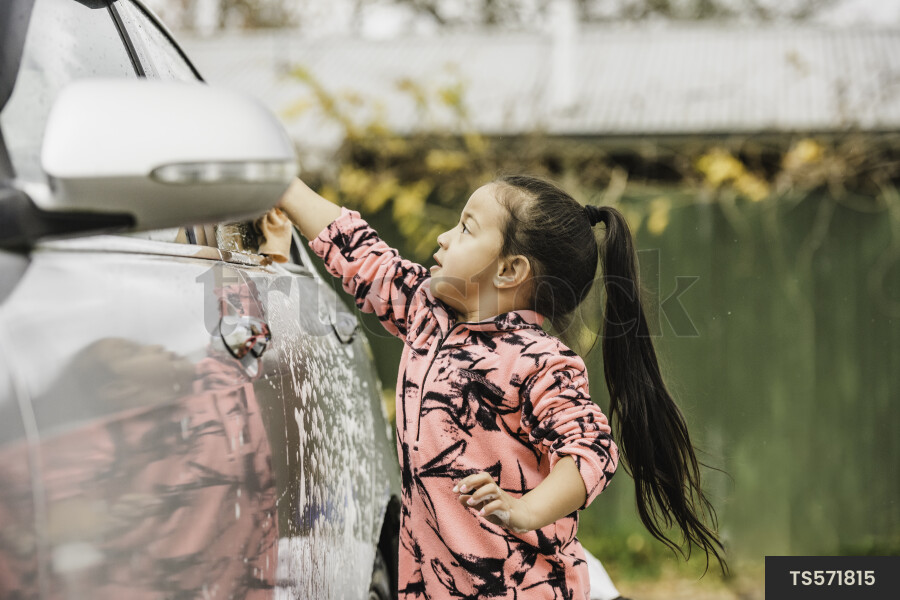 Maori girl washing car at home