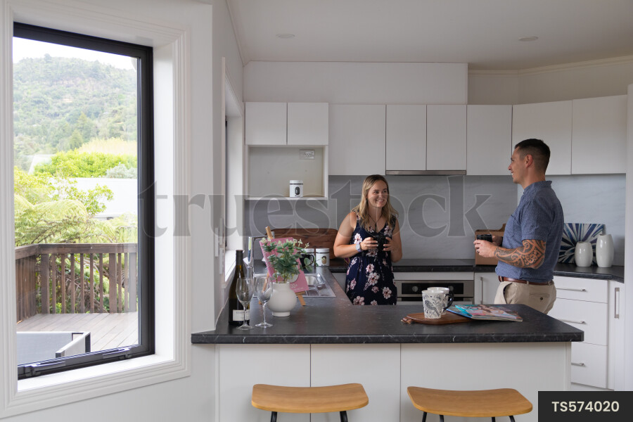 Couple with coffee cups in kitchen