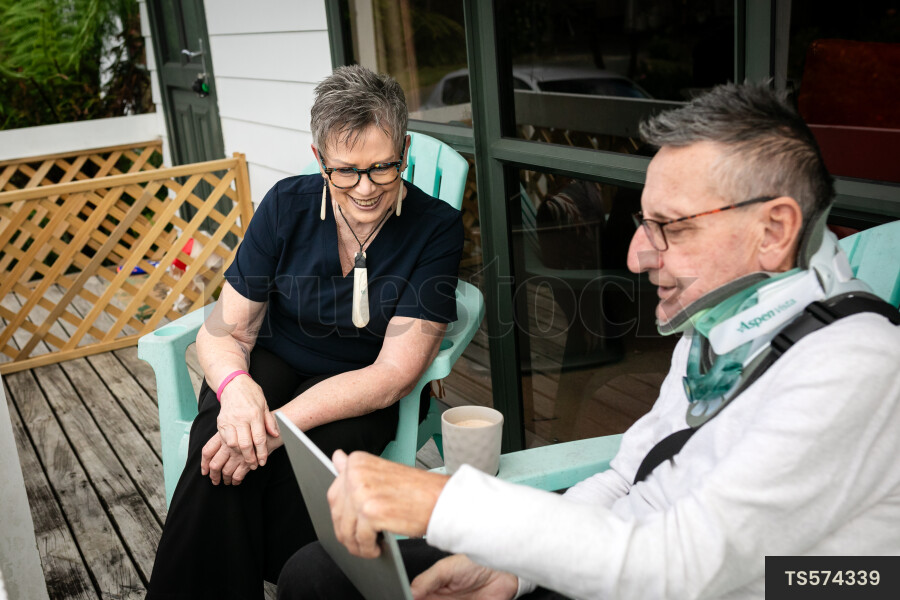Health carer sitting with patient on deck