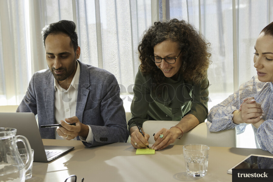 Colleagues Using Devices in Meeting