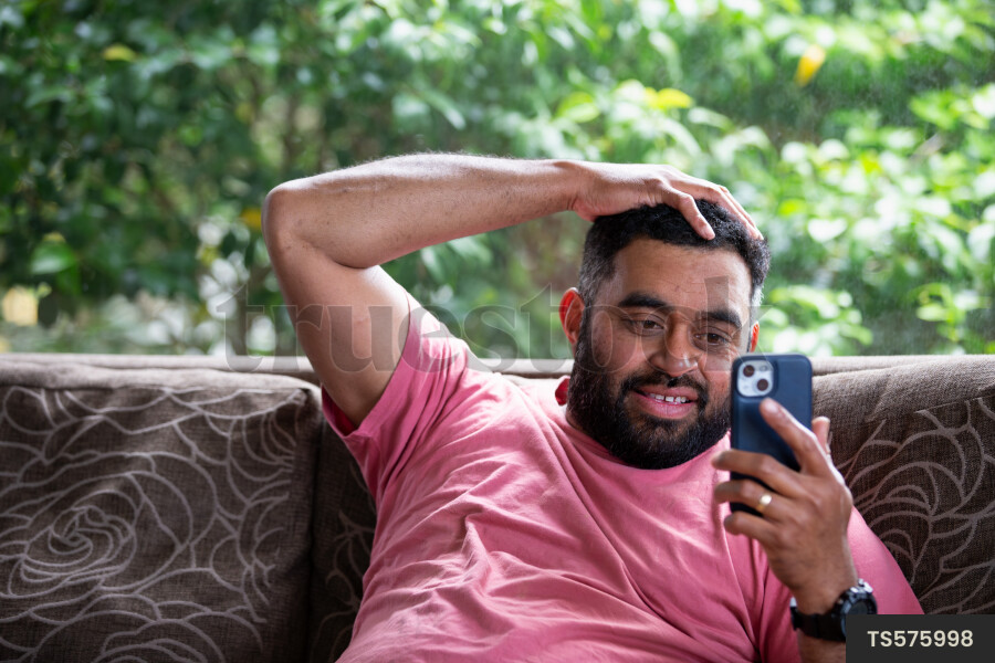 Man with smartphone sitting on sofa