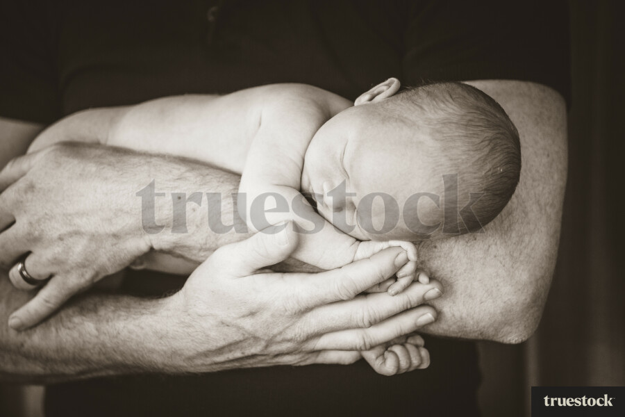 Sleeping baby resting in Father arms