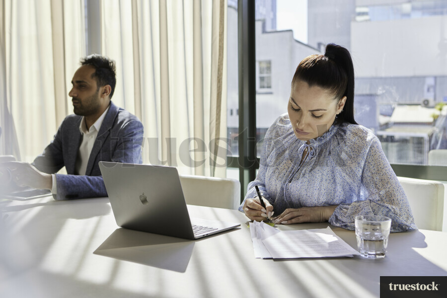 Woman Writing Notes in Meeting
