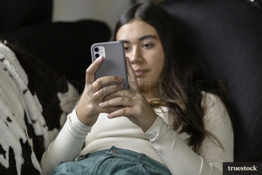 Teen Girl Using Phone on Couch