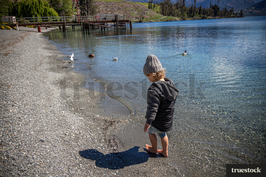 Child walking through the water at the lake