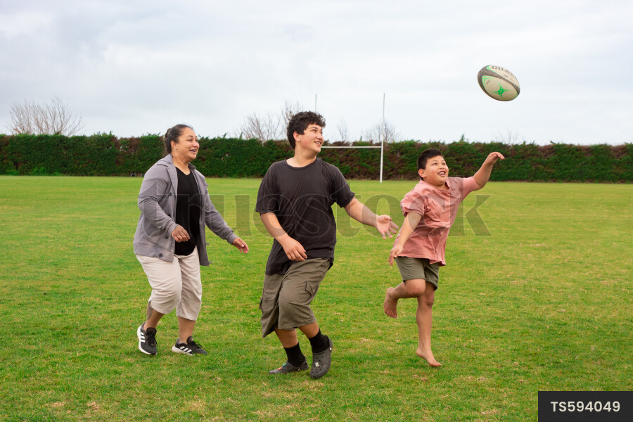 Child Parent Rugby Fans TS594049 Family Playing Rugby at School Field by Emma Diack - Truestock