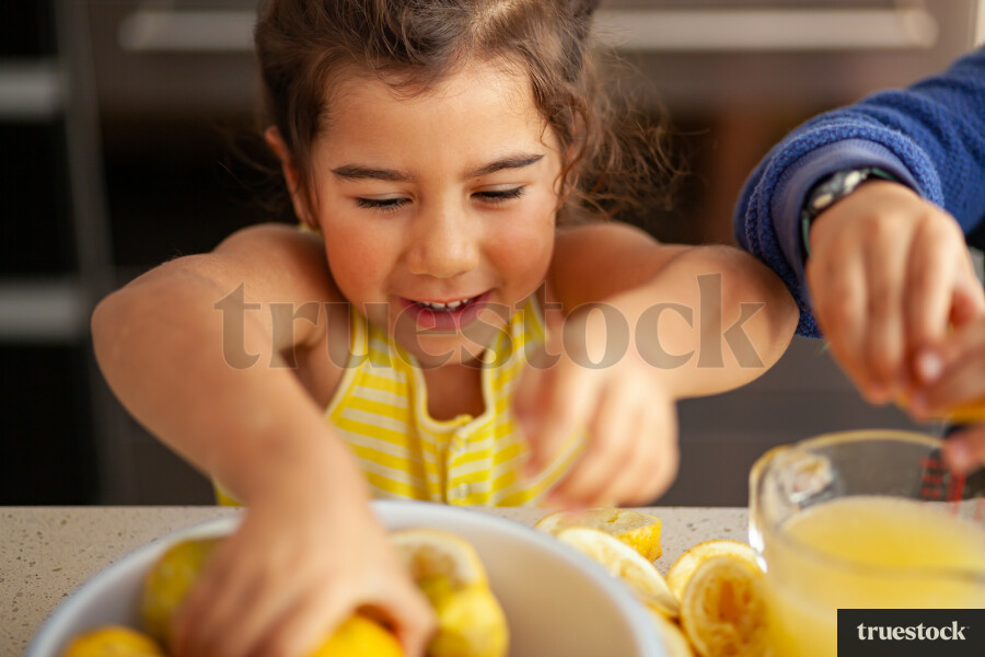 Young children making lemondade