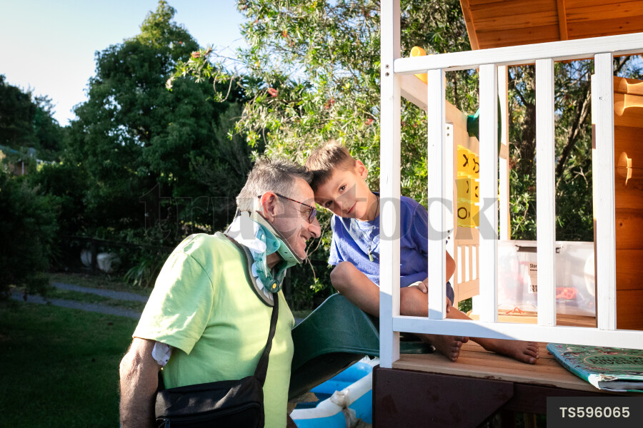 Man playing with grandson in playhouse