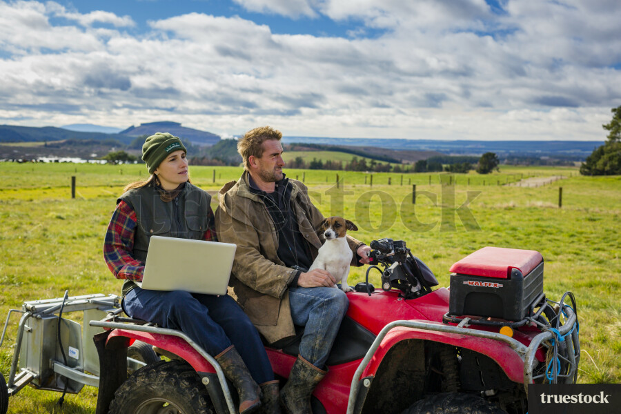 Farmers Using Laptop on Quad Bike