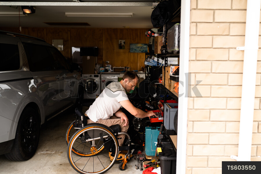 Man in wheelchair doing DIY in garage