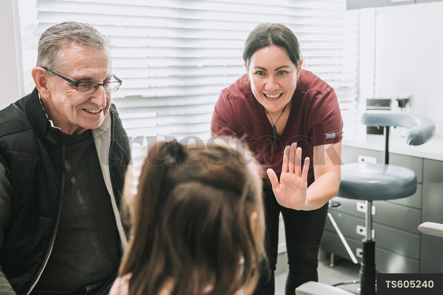Dentist giving high-five to patient in clinic