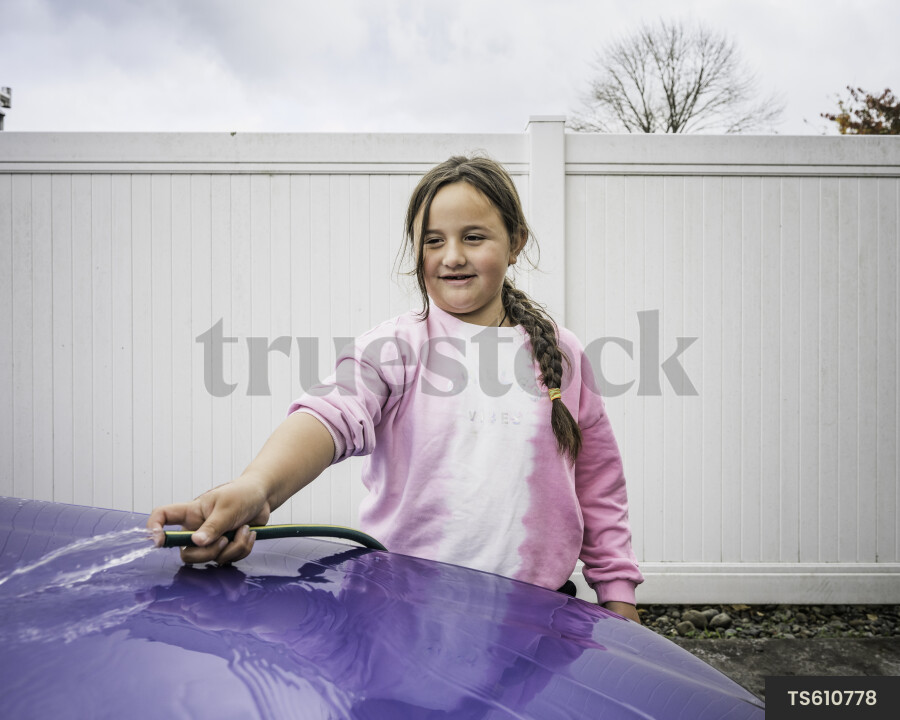 Maori girl washing car at home