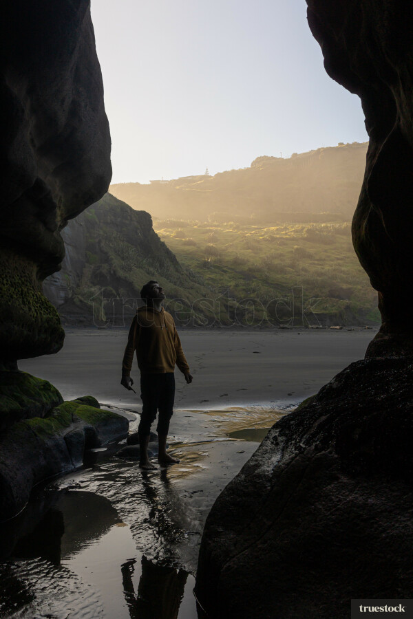 Man standing in Cave at Beach