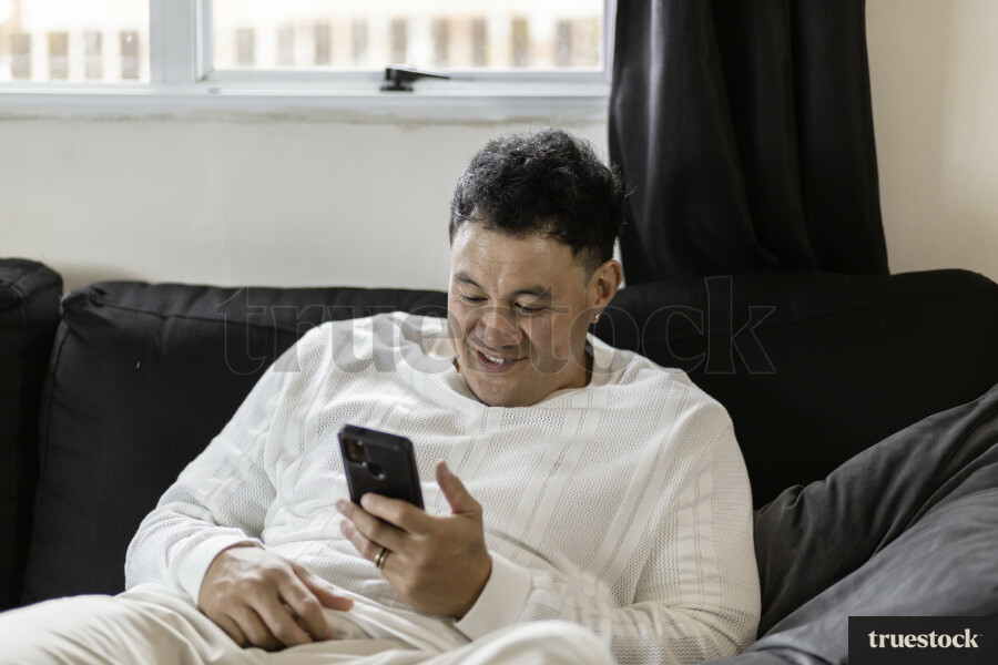Father Using Phone on Couch